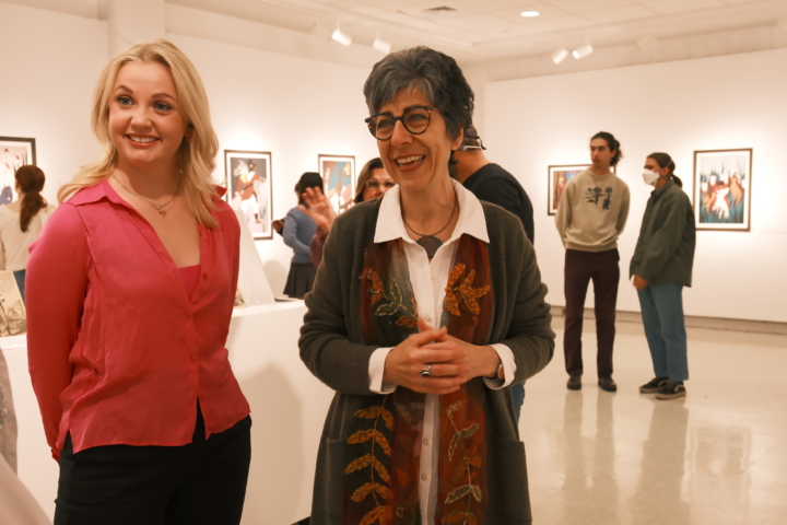 Professor Sibel Zandi-Sayek looks over the student-curated exhibit of Jacob Lawrence silkscreens with Emma Anderson '26.